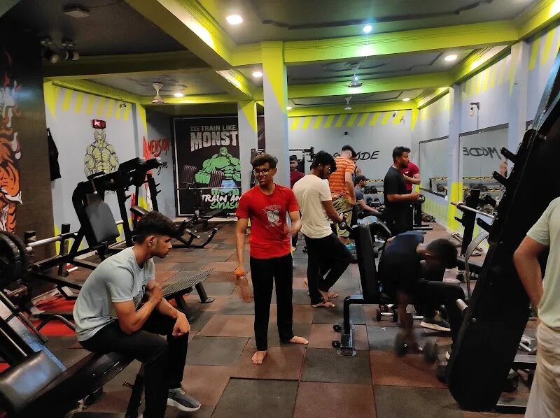 Members training on the busy main floor of Dimension Gym under a lit ceiling